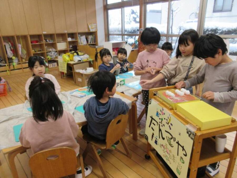 お団子職人たちが集まって何やらお団子屋さんをオープンする様子…いえいえただのお団子屋さんではありませんよ~ももたろうのおばあさんとおじいさんがやっているお団子屋さんなんです。みんなで「5たろうとおにがしま」というお話の世界を楽しんでいます。みんなでセリフや配役を考えて、衣装や小道具を作って劇あそびをします。幼稚園のみんなとも楽しみたい、面白くて楽しいお話です♪