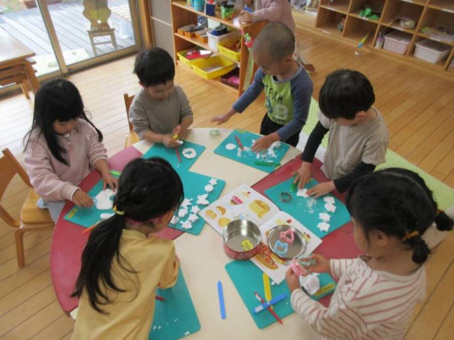 お店屋さんごっこが好きなゆり組さんにぴったりな絵本『かわうそカフェにいらっしゃい』の中にかわうそくんが考えた美味しそうなメニューが載っているページがあり、「かわいい~食べたい♡」ということで、クッキーを作ってみることにしました。いつも使っている粘土とは違う、紙粘土のフワフワな感触を楽しんだり、絵本を見ながらかわうそくんと一緒のクッキーを作ってみたりしました。最後にオーブンに入れて、焼きあがるのを今か今かと待ちながら、絵の具で味をつけて完成!!お客さんにも好評でしたよ!
