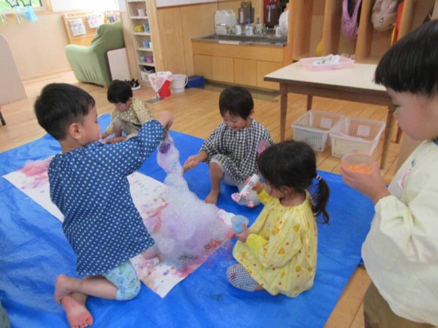 大きい小さいしゃぼん玉、いろんな道具を使ってみて…しゃぼん玉を楽しんでいるすみれ組さん。そして色にも興味があった子どもたち。しゃぼん液に色を付けて、バブルアートにチャレンジしてみました。白い紙の上で割れたしゃぼん玉が集まってきれいな模様に☆彡模様だけでなく、たくさん泡が集まる面白さにも気づき、お友だちと一緒に高いお山を作ろうとする姿も。しゃぼん玉の面白さをみんなで味わうことのできた活動でした。