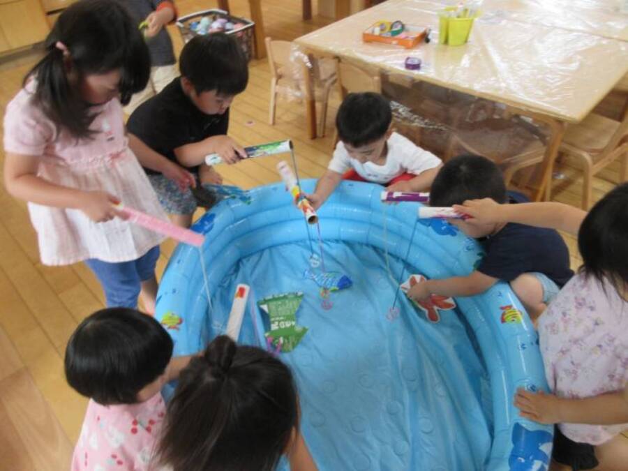 みんなで海を描き、海の生き物についてたくさん触れてきた7月、子どもたちから「これな~んだ」とクイズをするようにもなり、難しい名前の魚を覚えて教えてくれる様子も見られていますよ!朝はみんなで作った釣り竿・魚を使って魚釣りをする子どもたち、“かぶとむしのおうち”で遊んでいたお友だちやままごとコーナーで遊ぶお友だちも次第に「みんなで魚食べよう」と魚を釣って焼いて運んで食べる流れへと...猫役もいるらしく猫に魚...ぴったりですね(笑)