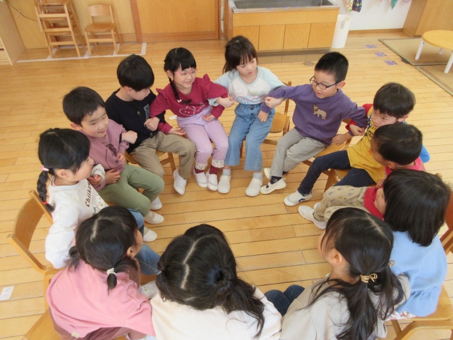 ひとりとひとりが腕組めば~♪1月はクラスでともだち賛歌を歌っています。毎月新しい季節の歌を教えると、「振り付けはどうする?」とちびっこ振付師たちのつぶやきがあり、話し合いが始まります(笑)話し合いの結果、歌詞に合わせた、座って歌う振り付けになりました。2番の振り付けも考えようとしたら、「“ロビンフッド”“トムソーヤ”“ポリネシア”ってどんな人?どこ?」と疑問が生まれ、「どんな人か分からないから調べてから振り付け決める」と疑問は解決しないと気が済まなくなっている子どもたちです。
