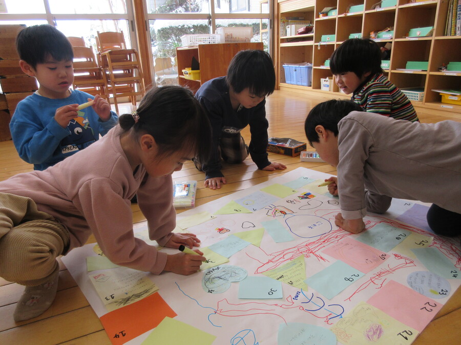 すごろく遊びをした後にみんなでゆり組オリジナルのすごろくを作ってみることにしました!”1から8にワープ” ”10回休み” ”ここにとまって1か2が出たらゴールへ飛ぶ”。色んなびっくり仰天マスを考える子どもたちでした!!”だれかとぎゅーする” ”ここにとまったら雪がふる”という可愛らしい発想のマスも出来て面白いすごろくが完成しました!